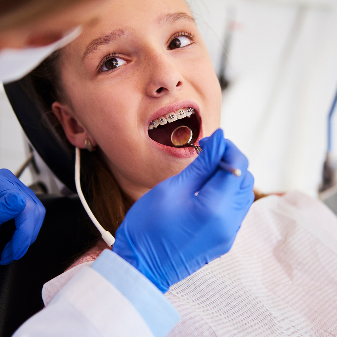 Young teen with braces at a dentist’s office.